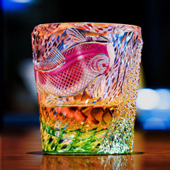 Edo Kiriko Kingyo Nishiki whisky glass glowing with amber drink and green crystal base
