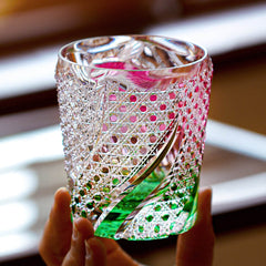 Edo Kiriko Kingyo Nishiki hand-cut whisky glass held in light with fish and water pattern