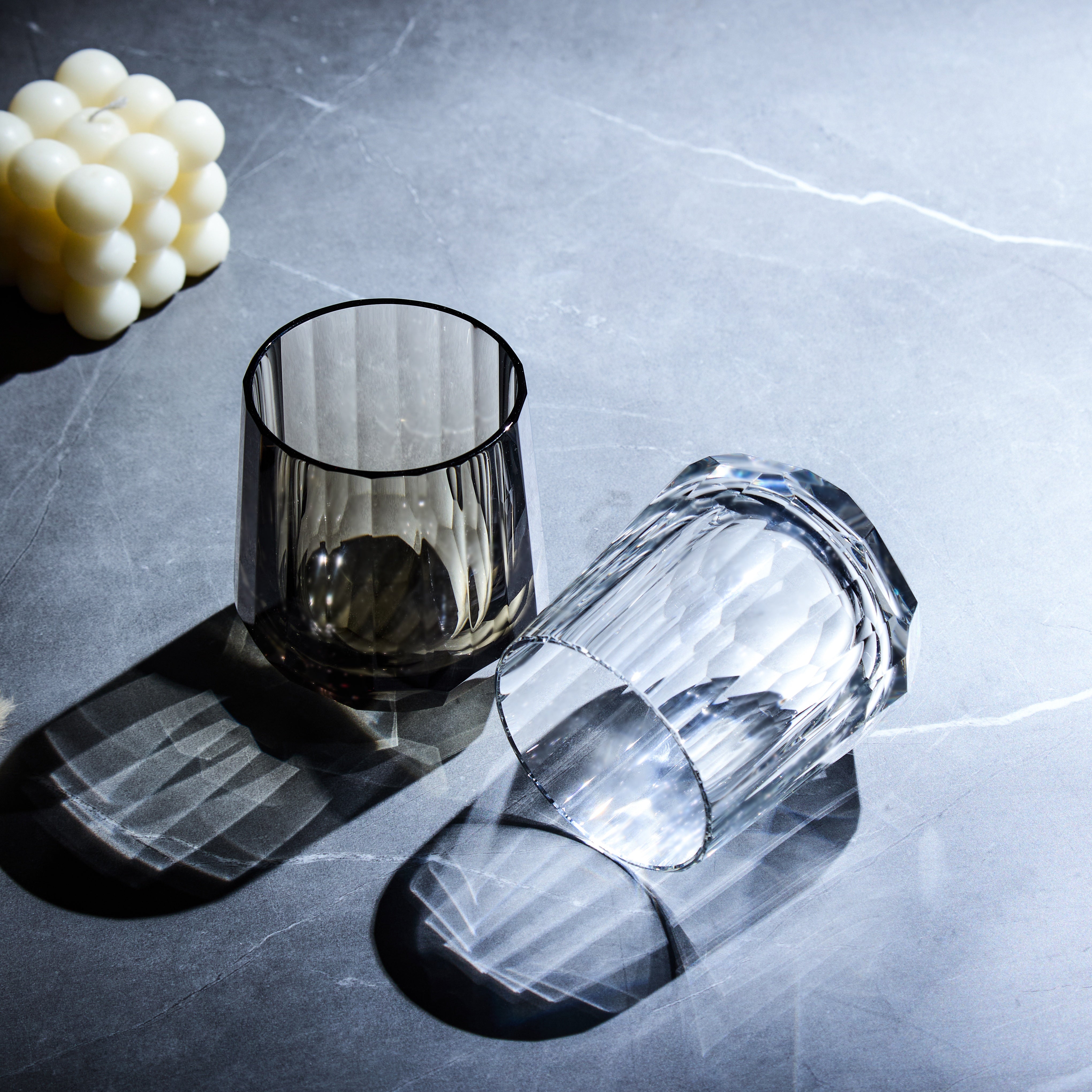 Edo Kiriko Kage-Tate whisky glasses with vertical cuts casting bold shadows on dark stone
