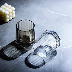 Edo Kiriko Kage-Tate whisky glasses with vertical cuts casting bold shadows on dark stone