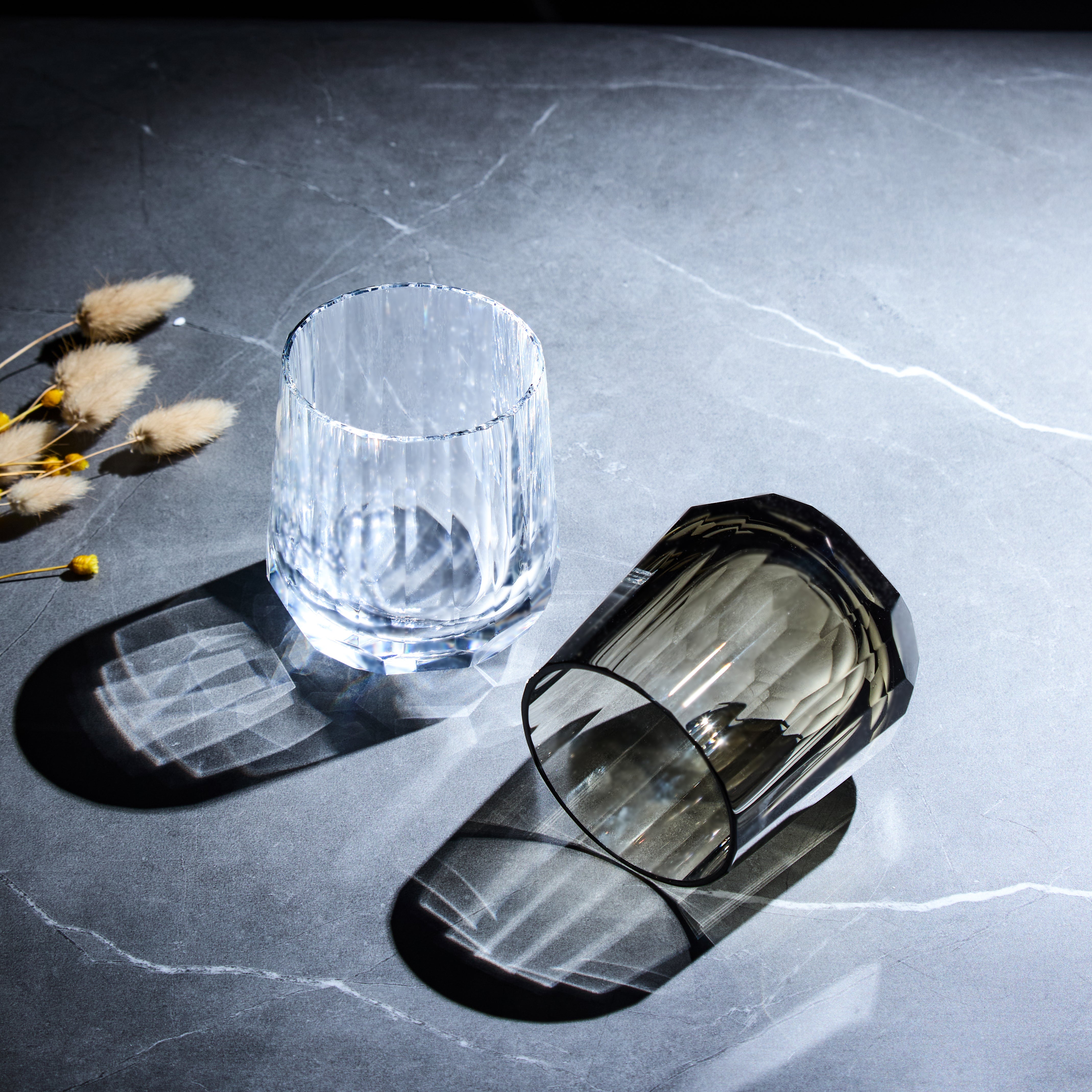 Edo Kiriko Kage-Tate whisky glasses in clear and smoky crystal with vertical cuts on stone surface