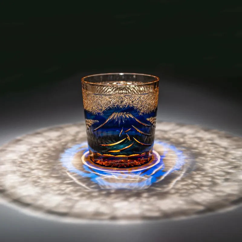 Edo Kiriko Mount Fuji Blue whisky glass on dark surface with circular light reflection