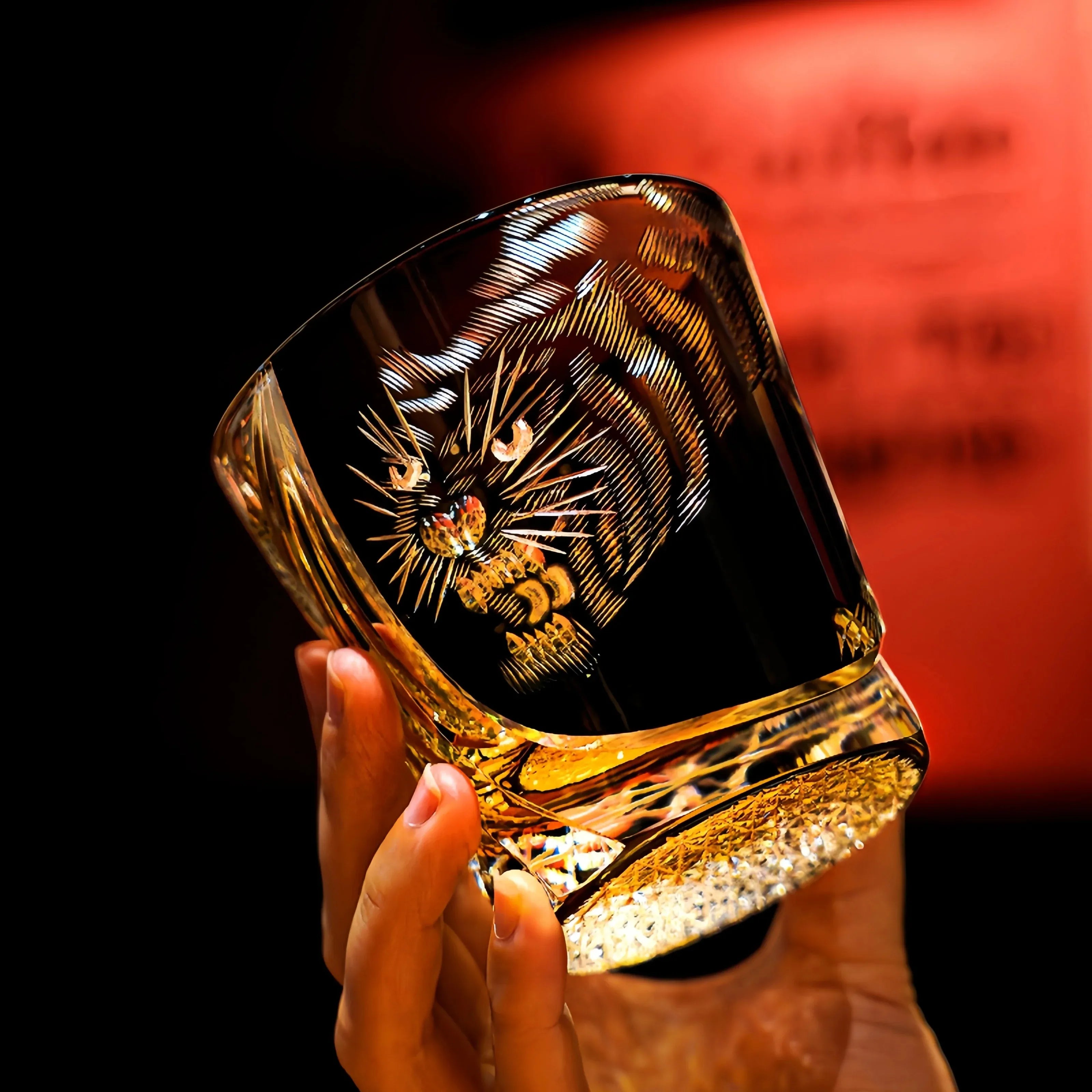 Edo Kiriko Kuro Tora whisky glass held by hand with black tiger motif and amber base