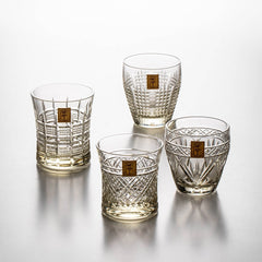 Four Kohaku Kiriko glasses in different shapes and cut patterns grouped on white