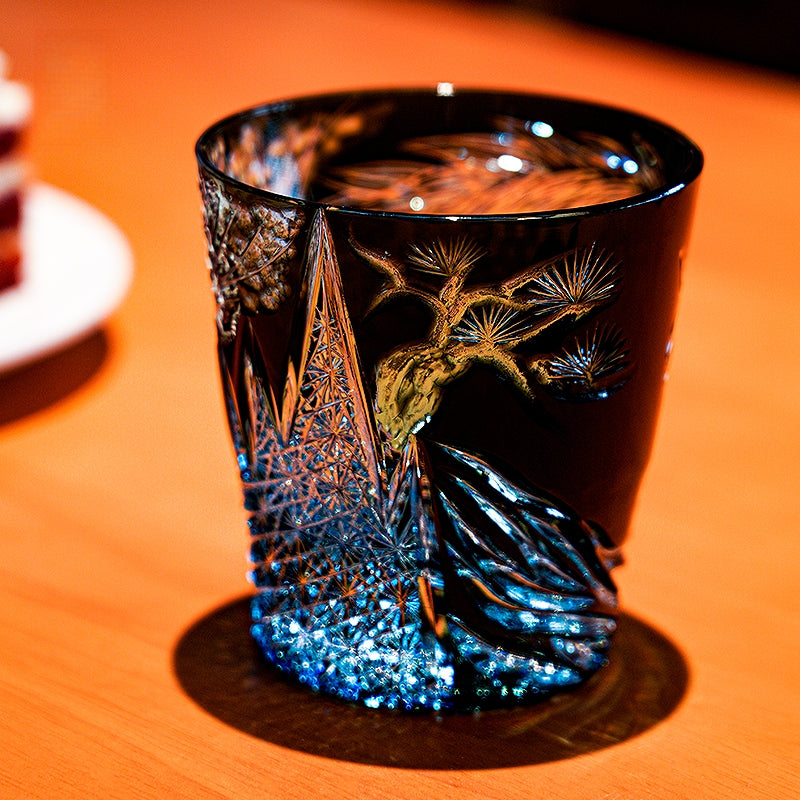 Dark blue Edo Kiriko old fashioned glass with gold motif and amber drink