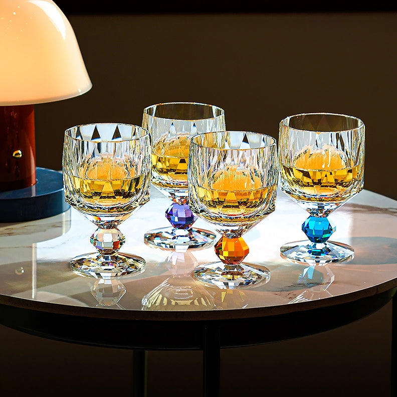 Four Prism-Cut glasses with amber pours, each on a differently coloured faceted crystal stem