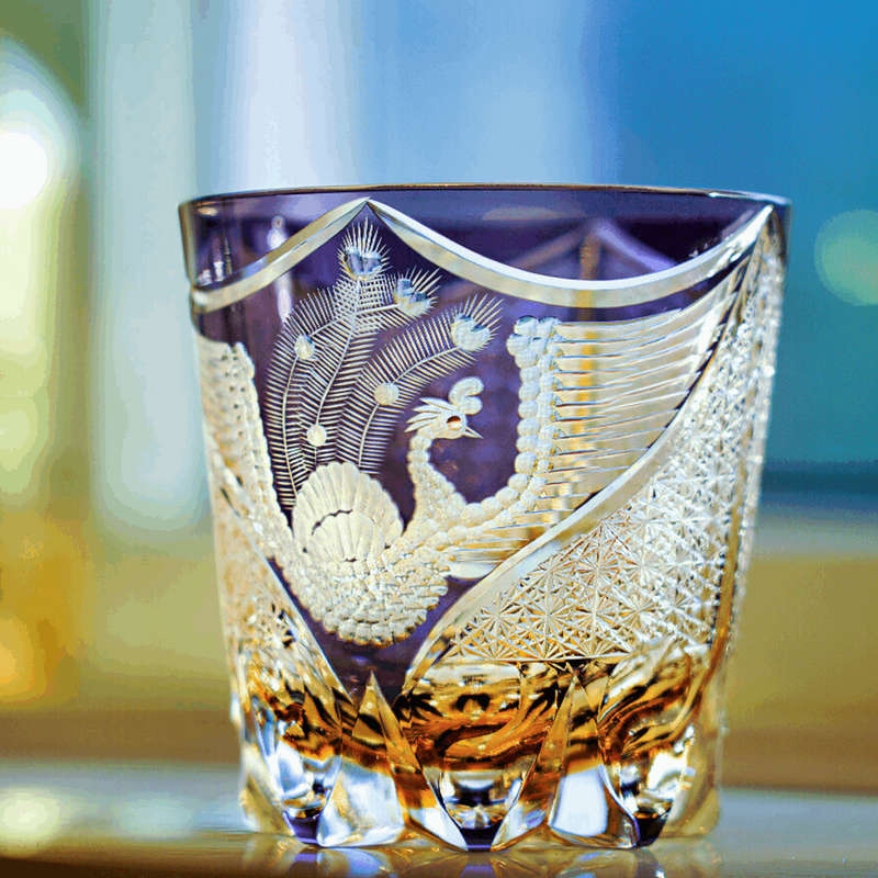 The Dancing Phoenix glass, a bird cut in relief through violet crystal above an amber base