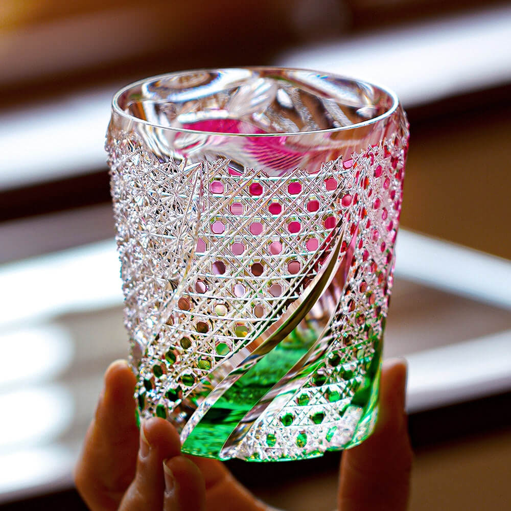Edo Kiriko Kingyo Nishiki hand-cut whisky glass held in light with fish and water pattern