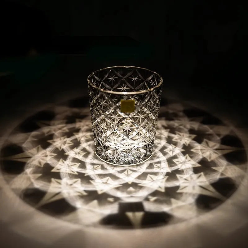 Edo Kiriko Starlight Crystal whisky glass casting radial light reflection on dark surface