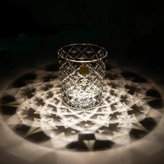 Edo Kiriko Starlight Crystal whisky glass casting radial light reflection on dark surface