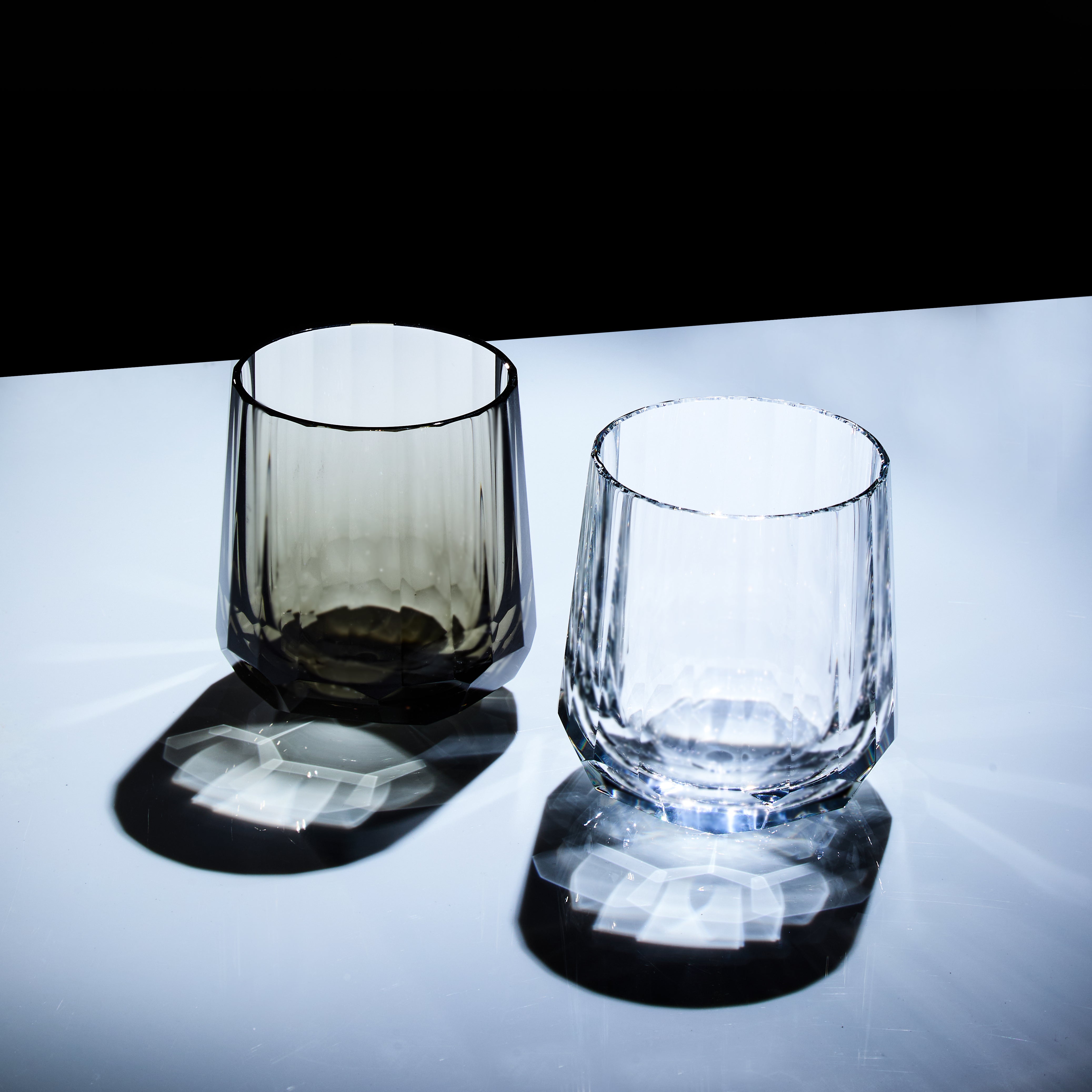 Clear and smoky Edo Kiriko Kage-Tate whisky glasses standing with strong shadow patterns