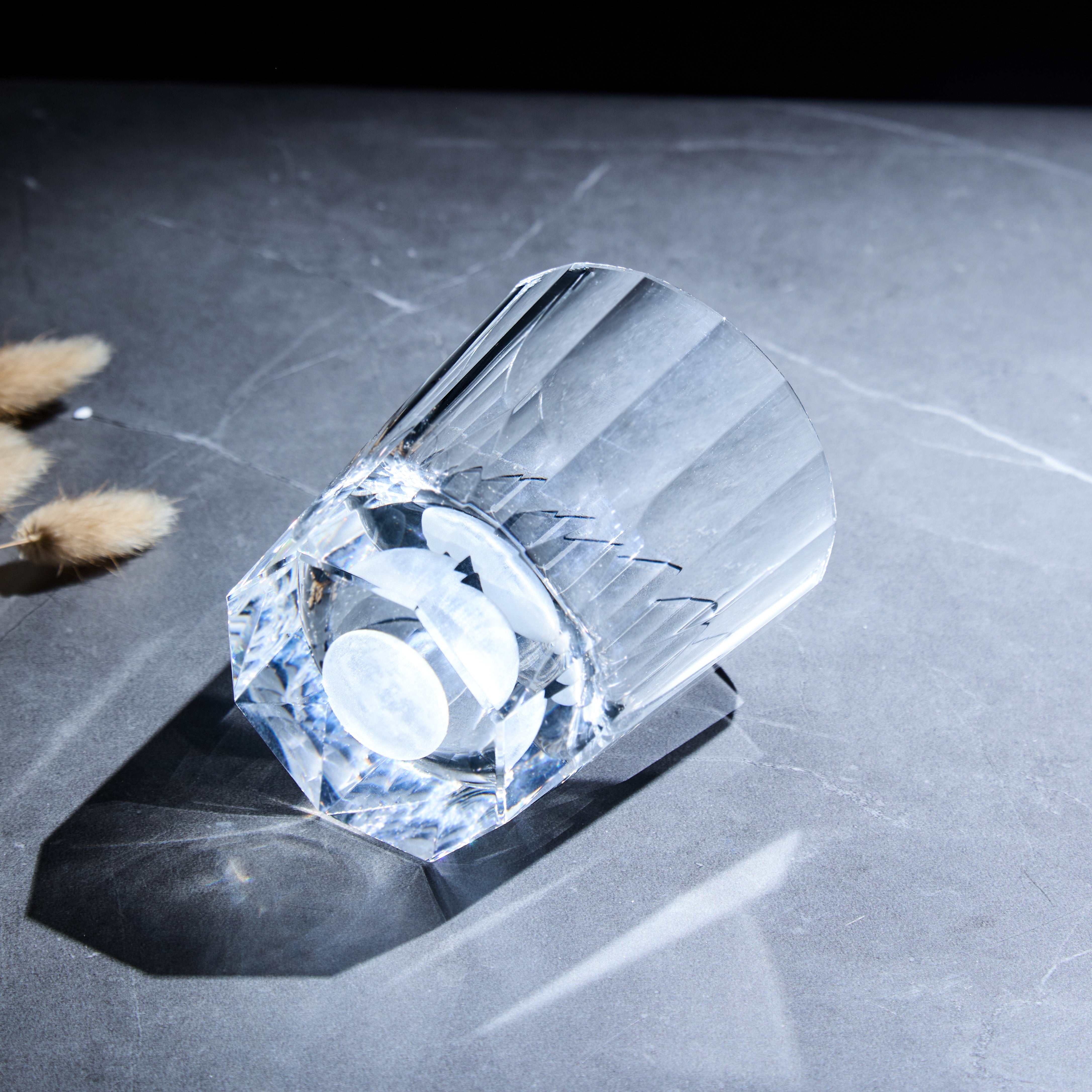 Edo Kiriko Tsukikage whisky glass lying on stone with circular moon base detail