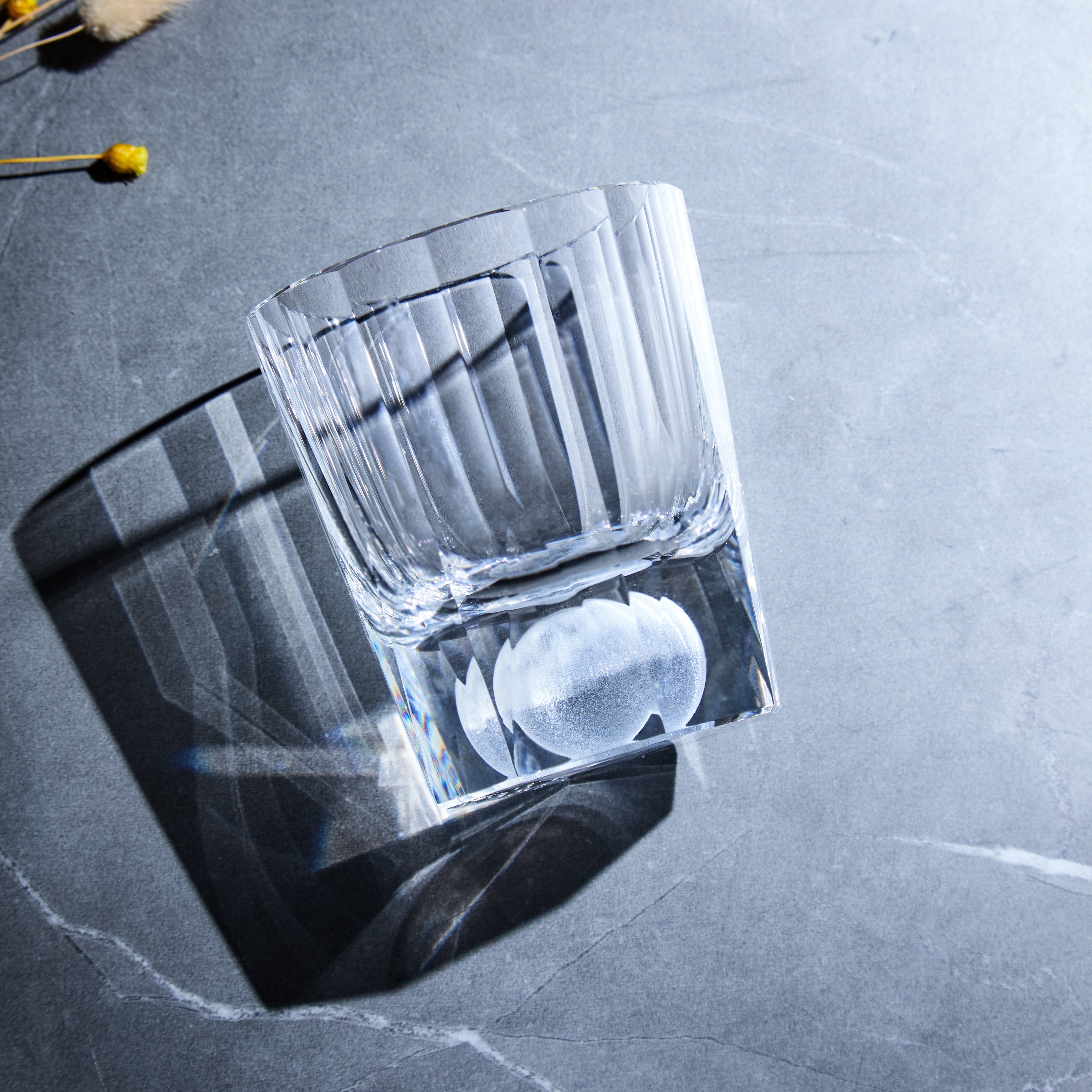 Edo Kiriko Tsukikage whisky glass on stone surface showing vertical cuts and clear base