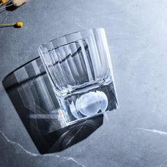 Edo Kiriko Tsukikage whisky glass on stone surface showing vertical cuts and clear base