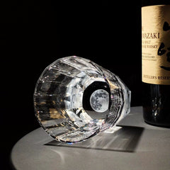 Edo Kiriko Tsukikage whisky glass lying beside whisky bottle with moon-like crystal base