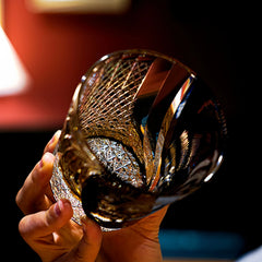 Edo Kiriko Kuro Tora whisky glass angled in hand showing hand-cut base detail