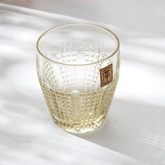 Empty Kohaku Nanako glass on a light table, with fine dotted cuts and a gold label