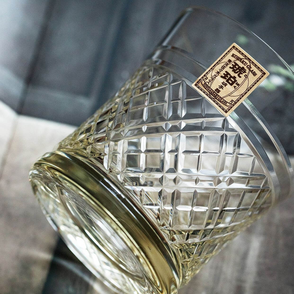 Kohaku Kagome glass lying on its side, showing crossed lattice cuts and paper label